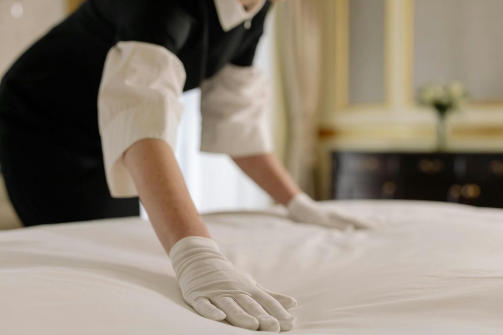 woman fixing the linen of a bed